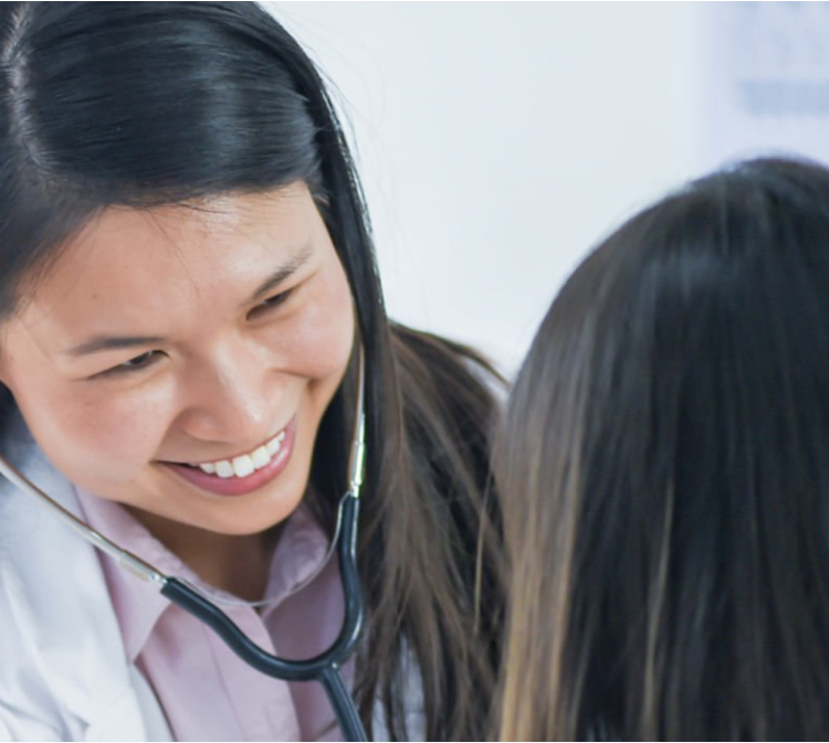 doctor smiling while treating patient using stethoscope